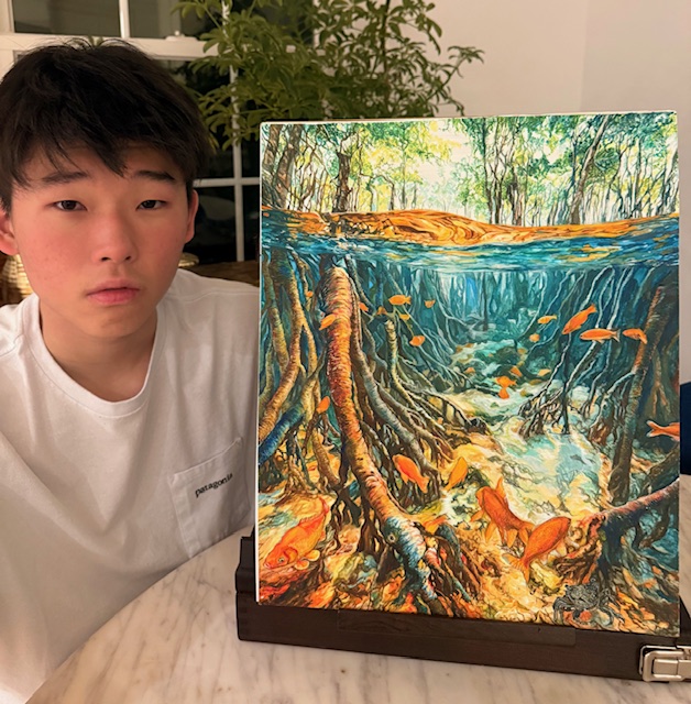 A photo of Daniel and his mangrove tree watercolor painting.